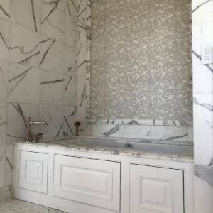Calacatta marble tub surround with decorative mosaic accent