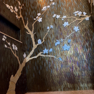 custom shower with glass mosaic and hand cut marble cherry tree inset into glass with a relief effect.